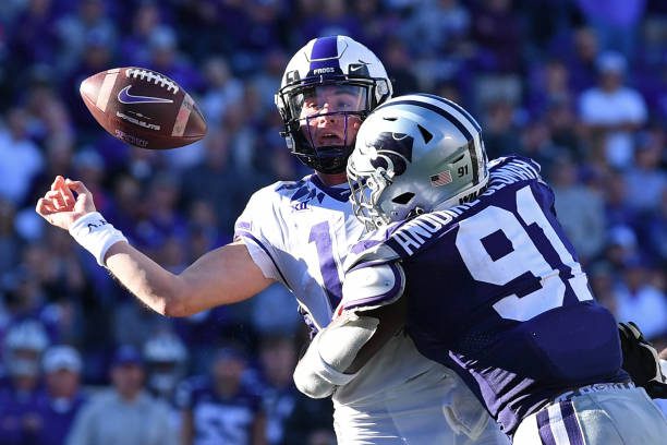 MANHATTAN, KS - OCTOBER 30:  Quarterback Chandler Morris #14 of the TCU Horned Frogs fumbles the ball after getting hit by defensive end Felix Anudike-Uzomah #91 of the Kansas State Wildcats, during the second half at Bill Snyder Family Football Stadium on October 30, 2021 in Manhattan, Kansas. (Photo by Peter Aiken/Getty Images)