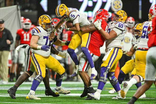 ATLANTA, GA  DECEMBER 03:  Georgia defensive lineman Jalen Carter (88) picks LSU quarterback Jayden Daniels (5) up off the ground during the SEC Championship football game between the LSU Tigers and the Georgia Bulldogs on December 3rd, 2022 at Mercedes-Benz Stadium in Atlanta, GA.  (Photo by Rich von Biberstein/Icon Sportswire via Getty Images)