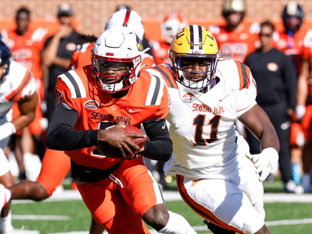 MOBILE, AL - FEBRUARY 04: Quarterback Malik Cunningham #7 of Louisville from the National Team avoids getting tackled from behind by Ali Gaye #11 of LSU from the American Team during the 2023 Resse's Senior Bowl at Hancock Whitney Stadium on the campus of the University of South Alabama on February 4, 2023 in Mobile, Alabama. The National defeated the American 27 to 10. (Photo by Don Juan Moore/Getty Images)