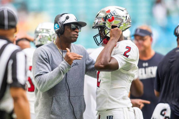 MIAMI GARDENS, FL - SEPTEMBER 05: Jackson State Tigers head coach Deion Sanders speaks with Jackson State Tigers quarterback Shedeur Sanders (2) during the Orange Blossom Classic game between the Florida A&amp;M Rattlers and the Jackson State Tigers on Sunday September 5th, 2021 at Hard Rock Stadium in Miami Gardens, FL.  (Photo by Nick Tre. Smith/Icon Sportswire via Getty Images)