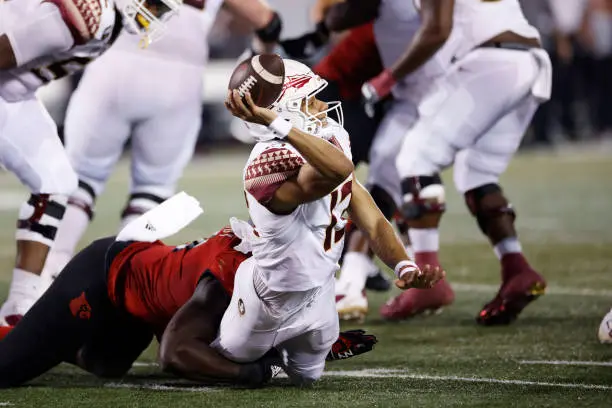 LOUISVILLE, KY - SEPTEMBER 16: Florida State Seminoles quarterback Jordan Travis (13) gets sacked by Louisville Cardinals linebacker Yasir Abdullah (22) resulting in an injury during a college football game on September 16, 2022 at Cardinals Stadium in Louisville, Kentucky. (Photo by Joe Robbins/Icon Sportswire via Getty Images)