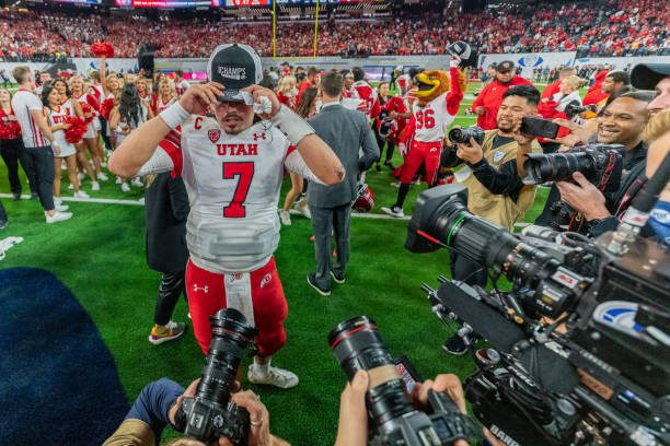 LAS VEGAS, NV - DECEMBER 2: Cameron Rising #7 of Utah puts on his championship hat during a game between the USC Trojans and the Utah Utes at Allegiant Stadium on December 2, 2022 in Las Vegas, Nevada. (Photo by Jason Allen/ISI Photos/Getty Images).