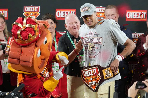 ORLANDO, FL - DECEMBER 29: Florida State Seminoles quarterback Jordan Travis (13) poses with the Cheez-It Bowl MVP trophy following the game between the Oklahoma Sooners and the Florida State Seminoles on Thursday, December 29, 2022 at Camping World Stadium, Orlando, Fla. (Photo by Peter Joneleit/Icon Sportswire via Getty Images)