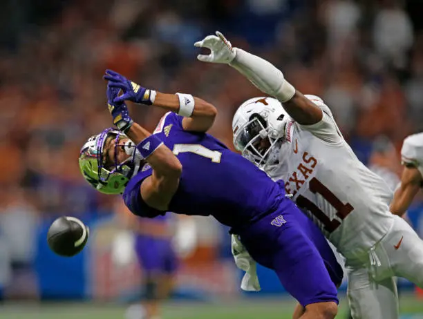 SAN ANTONIO, TX - DECEMBER 29: Anthony Cook #11 of the Texas Longhorns prevents Rome Odunze #1 of the Washington Huskies from making a reception in the first half in the Valero Alamo Bowl at the Alamodome on December 29, 2022 in San Antonio, Texas.  (Photo by Ronald Cortes/Getty Images)