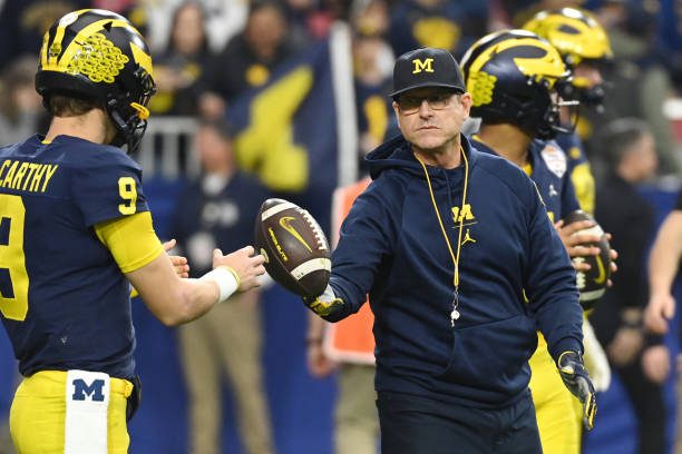 GLENDALE, ARIZONA - DECEMBER 31: Head coach Jim Harbaugh and J.J. McCarthy #9 of the Michigan Wolverines are seen during warmups prior to the game against the TCU Horned Frogs in the Vrbo Fiesta Bowl at State Farm Stadium on December 31, 2022 in Glendale, Arizona. (Photo by Norm Hall/Getty Images)