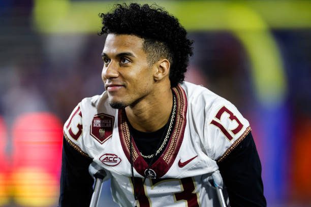 GAINESVILLE, FLORIDA - NOVEMBER 25: Jordan Travis #13 of the Florida State Seminoles looks on from the Seminoles bench before the start of a game against the Florida Gators at Ben Hill Griffin Stadium on November 25, 2023 in Gainesville, Florida. (Photo by James Gilbert/Getty Images)