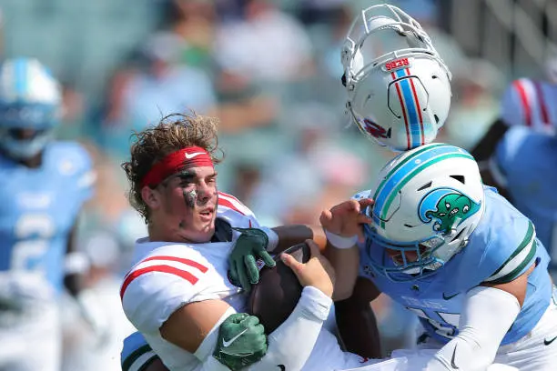 NEW ORLEANS, LOUISIANA - SEPTEMBER 09: Jaxson Dart #2 of the Mississippi Rebels is sacked by Jared Small #45 of the Tulane Green Wave and Jesus Machado #99 during the first half at Yulman Stadium on September 09, 2023 in New Orleans, Louisiana. (Photo by Jonathan Bachman/Getty Images)