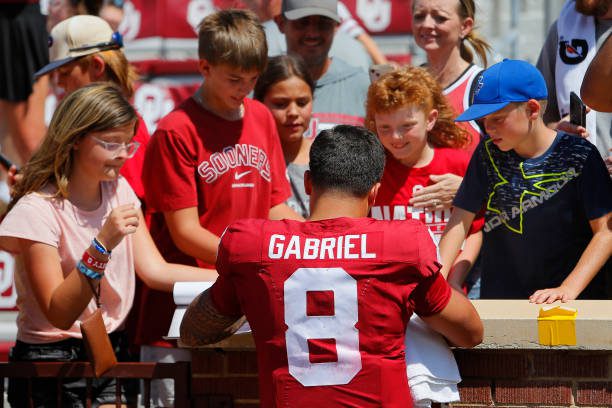 NORMAN, OKLAHOMA - SEPTEMBER 2:  Quarterback Dillon Gabriel #8 of the Oklahoma Sooners signs autographs for young fans after a game against the Arkansas State Red Wolves at Gaylord Family Oklahoma Memorial Stadium on September 2, 2023 in Norman, Oklahoma.  Oklahoma won 73-0. (Photo by Brian Bahr/Getty Images)