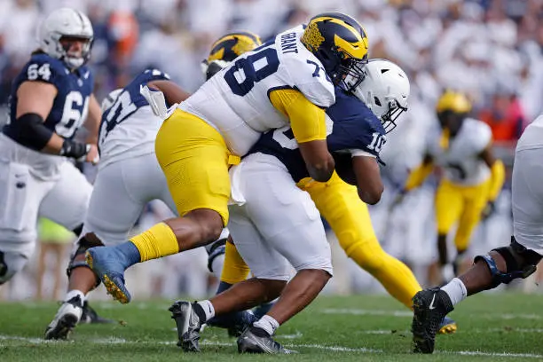 UNIVERSITY PARK, PA - NOVEMBER 11: Michigan Wolverines defensive lineman Kenneth Grant (78) tackles Penn State Nittany Lions running back Nicholas Singleton (10) for a loss of yardage during a college football game on November 11, 2023 at Beaver Stadium in University Park, Pennsylvania. (Photo by Joe Robbins/Icon Sportswire via Getty Images)