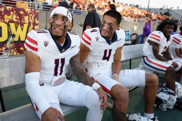 TEMPE, ARIZONA - NOVEMBER 25: Quarterback Noah Fifita #11 and wide receiver Tetairoa McMillan #4 of the Arizona Wildcats react on the bench during the final moments of the NCAAF game against the Arizona State Sun Devils at Mountain America Stadium on November 25, 2023 in Tempe, Arizona. The Wildcats defeated the Sun Devils 59-23. (Photo by Christian Petersen/Getty Images)