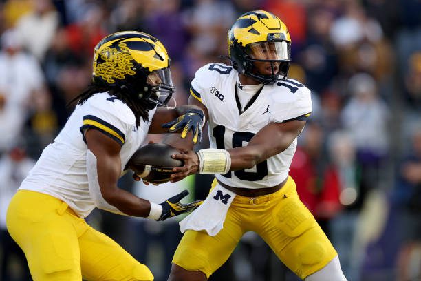 SEATTLE, WASHINGTON - OCTOBER 05: Alex Orji #10 hands the ball off to Donovan Edwards #7 of the Michigan Wolverines against the Washington Huskies at Husky Stadium on October 05, 2024 in Seattle, Washington. (Photo by Steph Chambers/Getty Images)