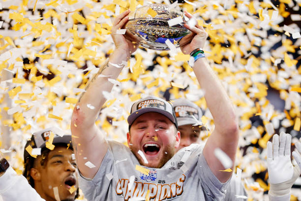 ATLANTA, GEORGIA - JANUARY 01: Quinn Ewers #3 of the Texas Longhorns holds the trophy after defeating the Arizona State Sun Devils 39-31 during the second overtime in the Chick-fil-A Peach Bowl at Mercedes-Benz Stadium on January 01, 2025 in Atlanta, Georgia.  (Photo by Todd Kirkland/Getty Images)