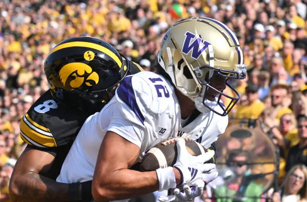 IOWA CITY, IA - OCTOBER 12: Iowa safety Deshaun (8) tackles Washington wide receiver Denzel Boston (12) as he catches a five-yard pass for a touchdown during a college football game between the Washington Huskies and the Iowa Hawkeyes, on October 12, 2024, at Kinnick Stadium, Iowa City, IA. (Photo by Keith Gillett/IconSportswire)