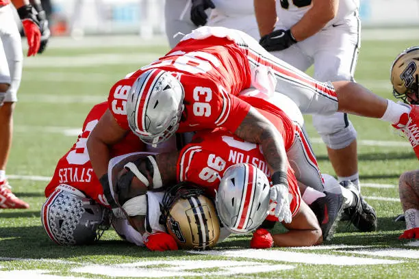 COLUMBUS, OH - NOVEMBER 09: Purdue Boilermakers running back Reggie Love III (23) is tackled by Ohio State Buckeyes safety Sonny Styles (6), defensive tackle Hero Kanu (93) and defensive end Eddrick Houston (96) during the game against the Purdue Boilermakers and the Ohio State Buckeyes on November 9, 2024, at Ohio Stadium in Columbus, OH. (Photo by Ian Johnson/Icon Sportswire via Getty Images)