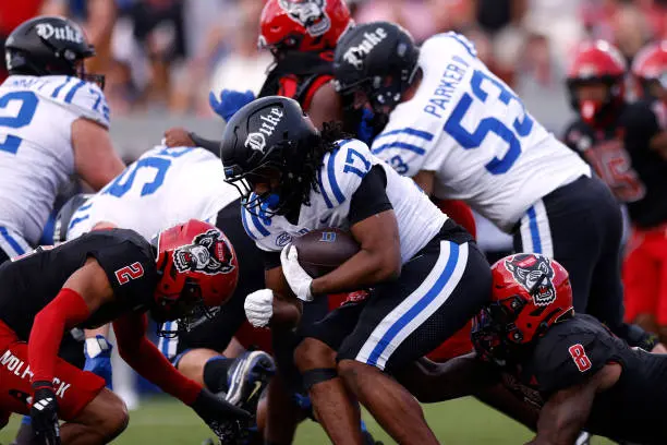 RALEIGH, NORTH CAROLINA - NOVEMBER 9: Star Thomas #17 of the Duke Blue Devils runs with the ball against Brandon Cisse #2 and Devon Betty #8 of the NC State Wolfpack at Carter-Finley Stadium on November 9, 2024 in Raleigh, North Carolina. (Photo by Lance King/Getty Images)