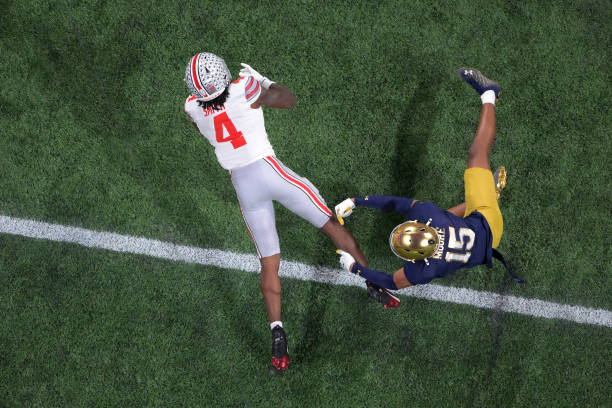 ATLANTA, GEORGIA - JANUARY 20: Jeremiah Smith #4 of the Ohio State Buckeyes is tackled by Leonard Moore #15 of the Notre Dame Fighting Irish during the first half in the 2025 CFP National Championship Game at Mercedes-Benz Stadium on January 20, 2025 in Atlanta, Georgia. (Photo by CFP/Getty Images)