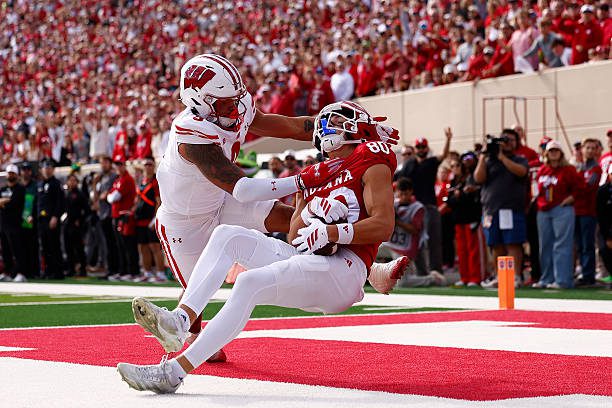 BLOOMINGTON, IN - NOVEMBER 15: Indiana Hoosiers wide receiver Charlie Becker (80) makes the catch for the touchdown while defended by Wisconsin Badgers safety Austin Brown (9) during a college football game between the Wisconsin Badgers and the Indiana Hoosiers on November 15, 2025 at Memorial Stadium in Bloomington, IN.  (Photo by Jeffrey Brown/Icon Sportswire via Getty Images)