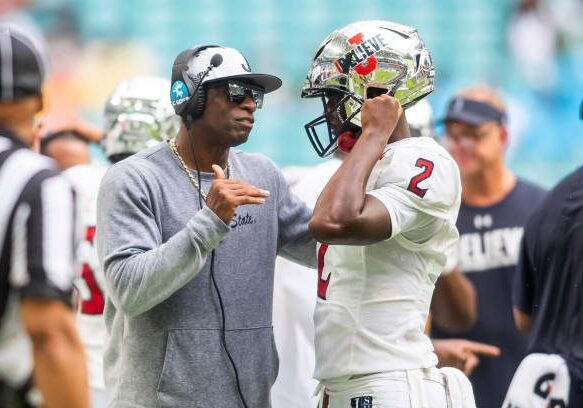 MIAMI GARDENS, FL - SEPTEMBER 05: Jackson State Tigers head coach Deion Sanders speaks with Jackson State Tigers quarterback Shedeur Sanders (2) during the Orange Blossom Classic game between the Florida A&amp;M Rattlers and the Jackson State Tigers on Sunday September 5th, 2021 at Hard Rock Stadium in Miami Gardens, FL.  (Photo by Nick Tre. Smith/Icon Sportswire via Getty Images)