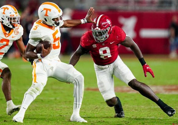 TUSCALOOSA, ALABAMA - OCTOBER 23: Hendon Hooker #5 of the Tennessee Volunteers tries to ge away from Christian Harris #8 of the Alabama Crimson Tide at Bryant Denny Stadium on October 23, 2021 in Tuscaloosa, Alabama (Photo by Marvin Gentry/Getty Images )