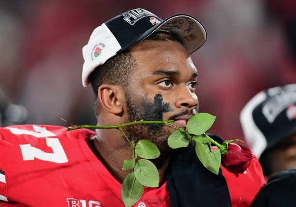 PASADENA, CA - JANUARY 01: Ohio State Buckeyes offensive lineman Paris Johnson Jr. (77) with a rose in his mouth after the Buckeyes defeated the Utah Utes 48 to 45 to become the Rose Bowl Champions in a bowl game played on January 1, 2022 at the Rose Bowl in Pasadena CA. (Photo by John Cordes/Icon Sportswire via Getty Images)