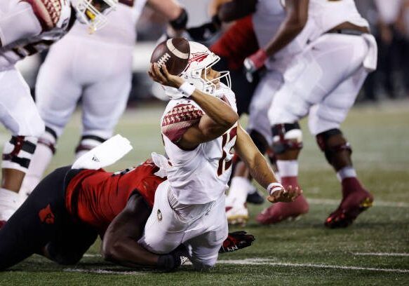 LOUISVILLE, KY - SEPTEMBER 16: Florida State Seminoles quarterback Jordan Travis (13) gets sacked by Louisville Cardinals linebacker Yasir Abdullah (22) resulting in an injury during a college football game on September 16, 2022 at Cardinals Stadium in Louisville, Kentucky. (Photo by Joe Robbins/Icon Sportswire via Getty Images)