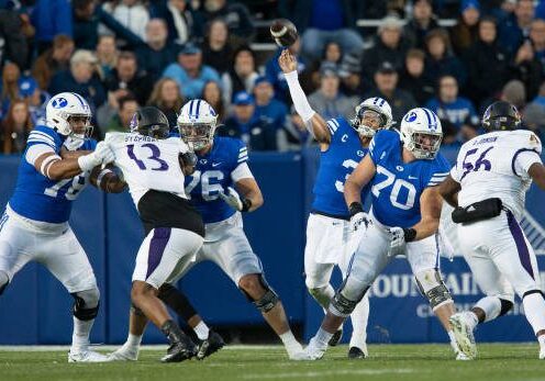 PROVO, UT - OCTOBER 28: Jaren Hall #3 of the Brigham Young Cougars throws a pass under pressure from Chad Stephens #13 and D'Anta Johnson #56 the East Carolina Pirates during the first half of their game at the LaVell Edwards Stadium on October 28, 2022 in Provo, Utah. (Photo by Chris Gardner/Getty Images)