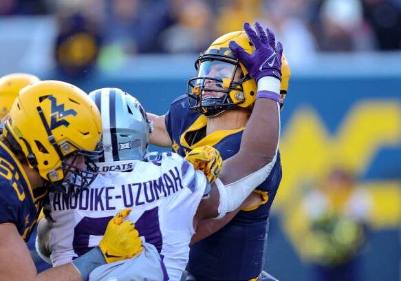 MORGANTOWN, WV - NOVEMBER 19: West Virginia Mountaineers quarterback Garrett Greene (6) is hit as he throws by Kansas State Wildcats defensive end Felix Anudike-Uzomah (91) during the third quarter of the college football game between the Kansas State Wildcats and the West Virginia Mountaineers on November 19, 2022, at Mountaineer Field at Milan Puskar Stadium in Morgantown, WV. (Photo by Frank Jansky/Icon Sportswire via Getty Images)