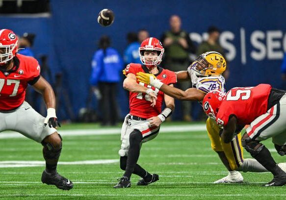 ATLANTA, GA  DECEMBER 03:  Georgia quarterback Stetson Bennett (13) throws a pass as he is hit by LSU defensive end BJ Ojulari (18) during the SEC Championship football game between the LSU Tigers and the Georgia Bulldogs on December 3rd, 2022 at Mercedes-Benz Stadium in Atlanta, GA.  (Photo by Rich von Biberstein/Icon Sportswire via Getty Images)