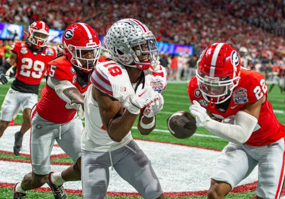 ATLANTA, GA - DECEMBER 31: Ohio State Buckeyes wide receiver Marvin Harrison Jr. (18) drops a touchdown pass as Georgia Bulldogs defensive back Javon Bullard (22) lays a big hit on Harrison Jr. during the Chick-fil-A Peach Bowl College Football Playoff Semifinal game between the Ohio State Buckeyes and the Georgia Bulldogs on December 31, 2022, at Mercedes-Benz Stadium in Atlanta, Georgia.  (Photo by John Adams/Icon Sportswire via Getty Images)