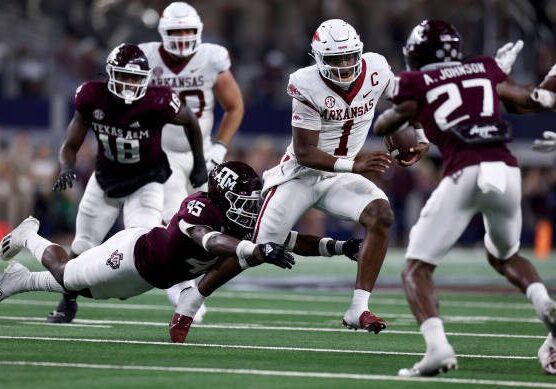 ARLINGTON, TEXAS - SEPTEMBER 24: Quarterback KJ Jefferson #1 of the Arkansas Razorbacks carries the ball against linebacker Edgerrin Cooper #45 of the Texas A&amp;M Aggies and defensive back Antonio Johnson #27 of the Texas A&amp;M Aggies in the fourth quarter of the 2022 Southwest Classic at AT&amp;T Stadium on September 24, 2022 in Arlington, Texas. (Photo by Tom Pennington/Getty Images)