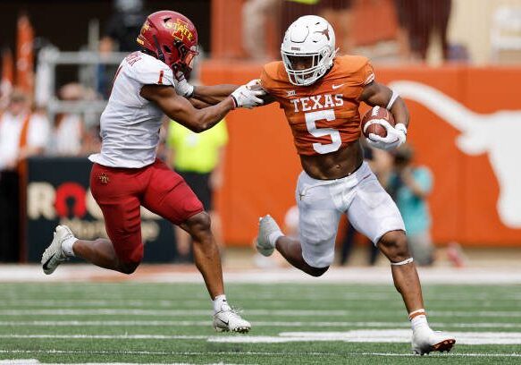 AUSTIN, TEXAS - OCTOBER 15: Bijan Robinson #5 of the Texas Longhorns runs the ball while defended by Anthony Johnson Jr. #1 of the Iowa State Cyclones in the first half at Darrell K Royal-Texas Memorial Stadium on October 15, 2022 in Austin, Texas. (Photo by Tim Warner/Getty Images)