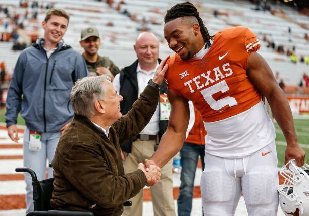 AUSTIN, TEXAS - NOVEMBER 25: Texas Governor Greg Abbott greets Bijan Robinson #5 of the Texas Longhorns after the game against the Baylor Bears at Darrell K Royal-Texas Memorial Stadium on November 25, 2022 in Austin, Texas. (Photo by Tim Warner/Getty Images)