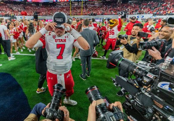 LAS VEGAS, NV - DECEMBER 2: Cameron Rising #7 of Utah puts on his championship hat during a game between the USC Trojans and the Utah Utes at Allegiant Stadium on December 2, 2022 in Las Vegas, Nevada. (Photo by Jason Allen/ISI Photos/Getty Images).