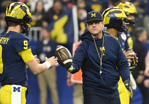 GLENDALE, ARIZONA - DECEMBER 31: Head coach Jim Harbaugh and J.J. McCarthy #9 of the Michigan Wolverines are seen during warmups prior to the game against the TCU Horned Frogs in the Vrbo Fiesta Bowl at State Farm Stadium on December 31, 2022 in Glendale, Arizona. (Photo by Norm Hall/Getty Images)