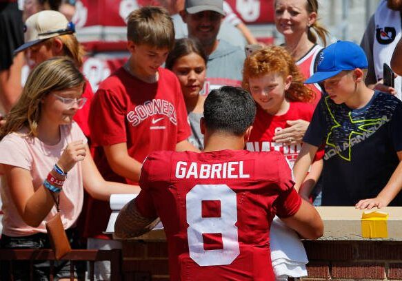 NORMAN, OKLAHOMA - SEPTEMBER 2:  Quarterback Dillon Gabriel #8 of the Oklahoma Sooners signs autographs for young fans after a game against the Arkansas State Red Wolves at Gaylord Family Oklahoma Memorial Stadium on September 2, 2023 in Norman, Oklahoma.  Oklahoma won 73-0. (Photo by Brian Bahr/Getty Images)