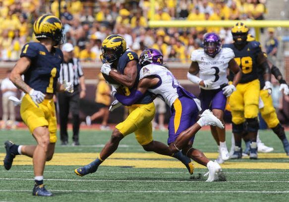 ANN ARBOR, MI - SEPTEMBER 02:  Michigan Wolverines wide receiver Cornelius Johnson (6) runs with the ball after catching a pass while trying to avoid being tackled by East Carolina Pirates defensive back Shavon Revel (28) during the third quarter of a non-conference college football game between the East Carolina Pirates and the Michigan Wolverines on September 2, 2023 at Michigan Stadium in Ann Arbor, Michigan.  (Photo by Scott W. Grau/Icon Sportswire via Getty Images)