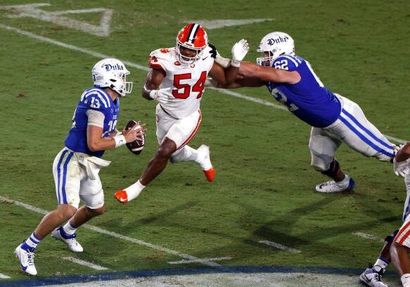 DURHAM, NORTH CAROLINA - SEPTEMBER 04: Jeremiah Trotter Jr. #54 of the Clemson Tigers gets past Graham Barton #62 of the Duke Blue Devils at Wallace Wade Stadium on September 4, 2023 in Durham, North Carolina. Duke won 28-7. (Photo by Lance King/Getty Images)