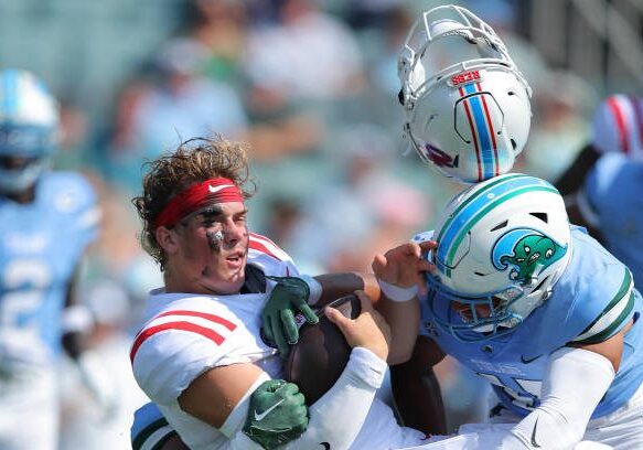 NEW ORLEANS, LOUISIANA - SEPTEMBER 09: Jaxson Dart #2 of the Mississippi Rebels is sacked by Jared Small #45 of the Tulane Green Wave and Jesus Machado #99 during the first half at Yulman Stadium on September 09, 2023 in New Orleans, Louisiana. (Photo by Jonathan Bachman/Getty Images)