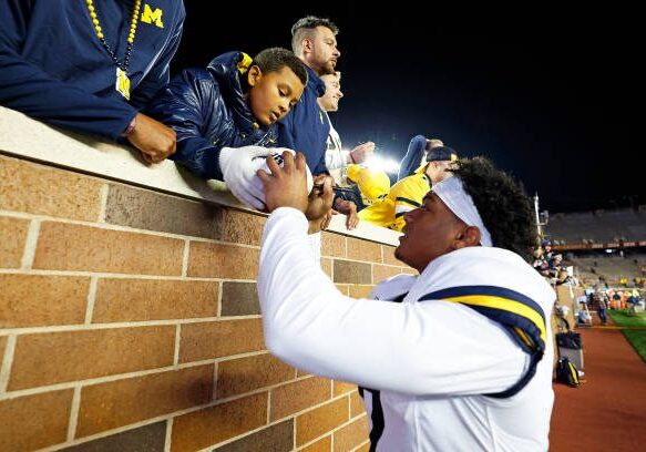 MINNEAPOLIS, MINNESOTA - OCTOBER 07: Will Johnson #2 of the Michigan Wolverines signs an autograph for a fan after the game against the Minnesota Golden Gophers at Huntington Bank Stadium on October 07, 2023 in Minneapolis, Minnesota. The Wolverines defeated the Golden Gophers 52-10. (Photo by David Berding/Getty Images)
