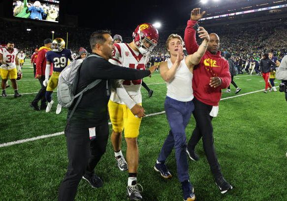SOUTH BEND, INDIANA - OCTOBER 14: A fan takes a selfie with Caleb Williams #13 of the USC Trojans after the Notre Dame Fighting Irish defeated the USC Trojans and rushed the field at Notre Dame Stadium on October 14, 2023 in South Bend, Indiana. (Photo by Michael Reaves/Getty Images)