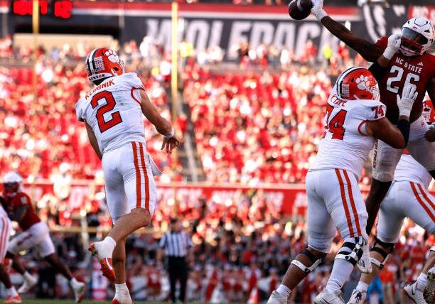 RALEIGH, NORTH CAROLINA - OCTOBER 28: Devon Betty #26 of the NC State Wolfpack bats a pass by Cade Klubnik #2 of the Clemson Tigers during the second half of the game at Carter-Finley Stadium on October 28, 2023 in Raleigh, North Carolina. NC State won 24-17. (Photo by Lance King/Getty Images)