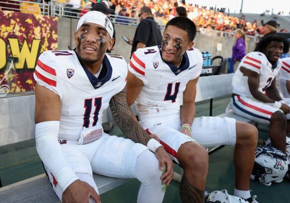 TEMPE, ARIZONA - NOVEMBER 25: Quarterback Noah Fifita #11 and wide receiver Tetairoa McMillan #4 of the Arizona Wildcats react on the bench during the final moments of the NCAAF game against the Arizona State Sun Devils at Mountain America Stadium on November 25, 2023 in Tempe, Arizona. The Wildcats defeated the Sun Devils 59-23. (Photo by Christian Petersen/Getty Images)