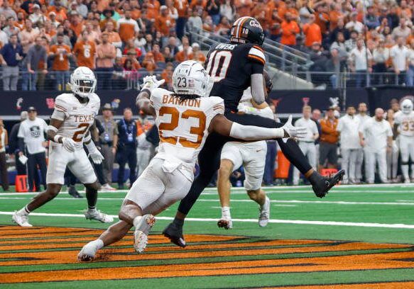 ARLINGTON, TX - DECEMBER 02: Oklahoma State Cowboys wide receiver Rashod Owens (10) catches a pass for a touchdown over Texas Longhorns defensive back Jahdae Barron (23) during the game between the Texas Longhorns and the Oklahoma State Cowboys on December 2, 2023 at AT&amp;T Stadium in Arlington, Texas. (Photo by Matthew Pearce/Icon Sportswire via Getty Images)