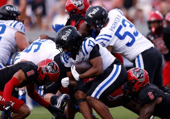 RALEIGH, NORTH CAROLINA - NOVEMBER 9: Star Thomas #17 of the Duke Blue Devils runs with the ball against Brandon Cisse #2 and Devon Betty #8 of the NC State Wolfpack at Carter-Finley Stadium on November 9, 2024 in Raleigh, North Carolina. (Photo by Lance King/Getty Images)