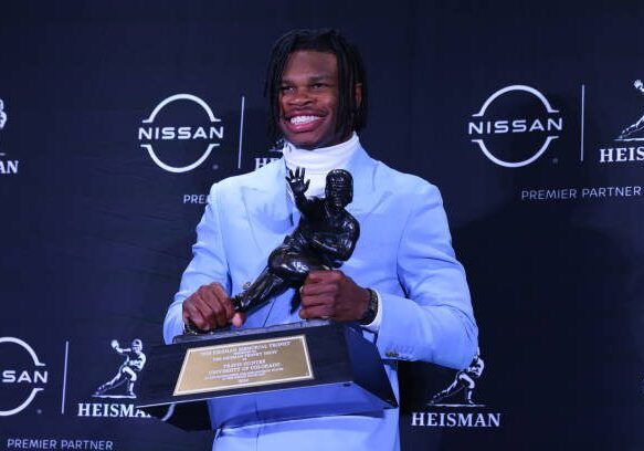 NEW YORK, NY - DECEMBER 14:  Travis Hunter University of Colorado cornerback/wide receiver poses with the Trophy during the Heisman Trophy press conference at the Marriott Marquis on December 14, 2024 in New York, New York. (Photo by Rich Graessle/Icon Sportswire via Getty Images)