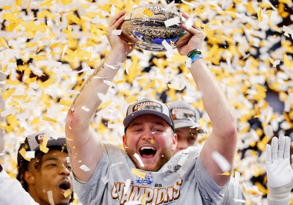 ATLANTA, GEORGIA - JANUARY 01: Quinn Ewers #3 of the Texas Longhorns holds the trophy after defeating the Arizona State Sun Devils 39-31 during the second overtime in the Chick-fil-A Peach Bowl at Mercedes-Benz Stadium on January 01, 2025 in Atlanta, Georgia.  (Photo by Todd Kirkland/Getty Images)