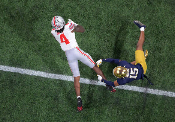ATLANTA, GEORGIA - JANUARY 20: Jeremiah Smith #4 of the Ohio State Buckeyes is tackled by Leonard Moore #15 of the Notre Dame Fighting Irish during the first half in the 2025 CFP National Championship Game at Mercedes-Benz Stadium on January 20, 2025 in Atlanta, Georgia. (Photo by CFP/Getty Images)
