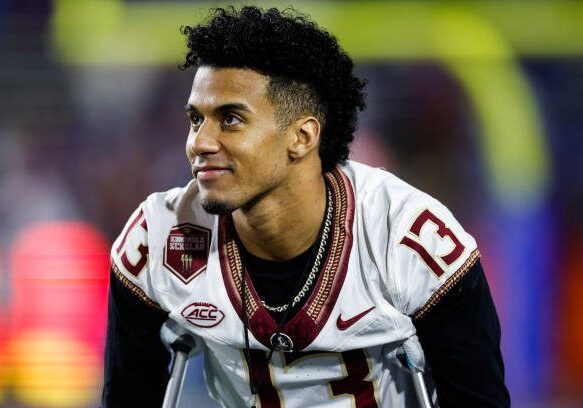 GAINESVILLE, FLORIDA - NOVEMBER 25: Jordan Travis #13 of the Florida State Seminoles looks on from the Seminoles bench before the start of a game against the Florida Gators at Ben Hill Griffin Stadium on November 25, 2023 in Gainesville, Florida. (Photo by James Gilbert/Getty Images)